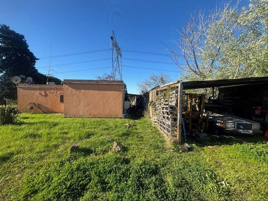 Terreno tipo chacra con casa y galpónes, con 205 m de frent